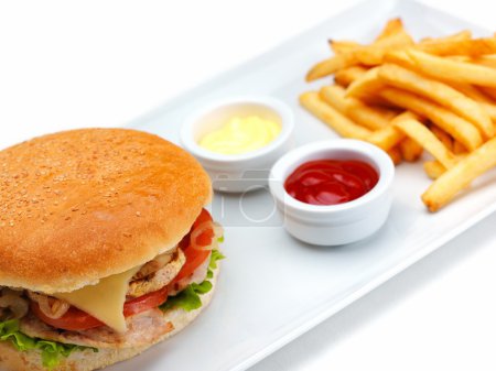 Tasty hamburger with sauces and french fries