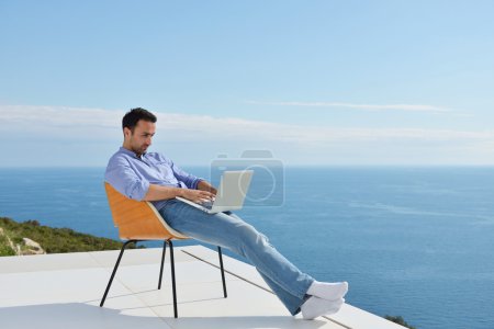 Man on balcony with computer