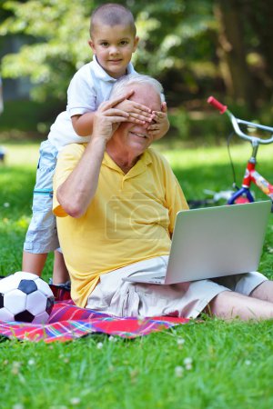 grandfather and child using laptop