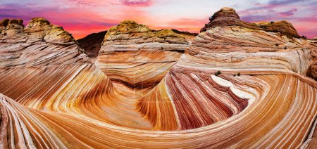 Sunset over the Wave in Arizona in the USA. The Wave is an awesome vivid swirling petrified dune sandstone formation in Coyote Buttes North. It could be seen in Paria Canyon-Vermilion Cliffs Wilderness. Panoramic photo