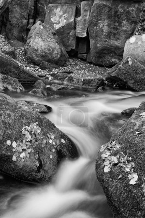 Blurred water detail with rocks nad Autumn leaves in Padley Gorg