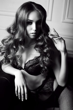 beautiful young woman with dark curly hair wears elegant lace lingerie 