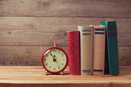 Books and clock on wooden table