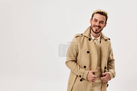 Cheerful man in coat posing on  isolated background. High quality photo