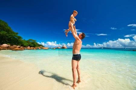 Father and two year old boy playing on beach