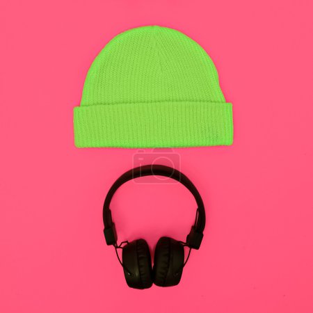 Stylish fashion accessories: hat and headphones on a pink backgr