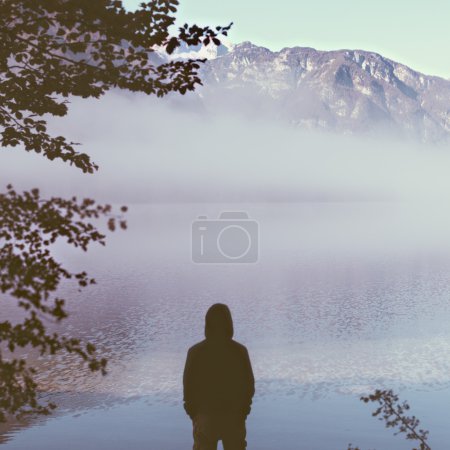 Man tourist in thick fog on the lake enjoying life.
