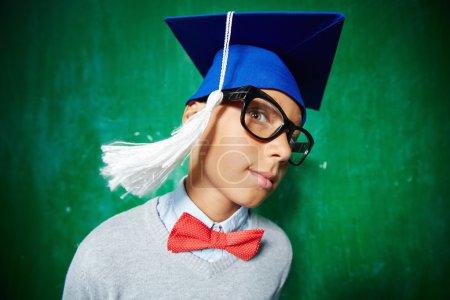Schoolboy in eyeglasses and graduation hat