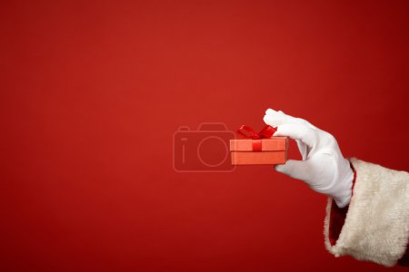 Santa hand holding red package