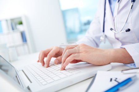 Nurse typing on laptop