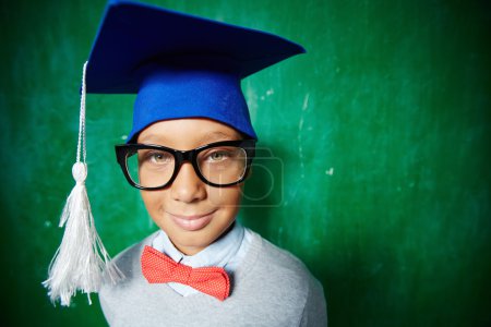 Elementary learner in eyeglasses and graduation hat