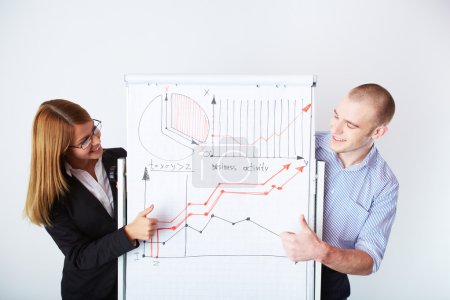 business partners looking at whiteboard with graph