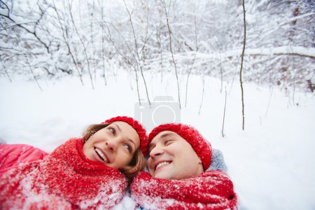 Man and woman lying in snow