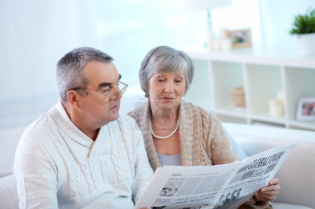 Senior couple reading newspaper