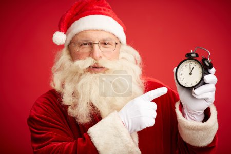 Santa Claus pointing at clock