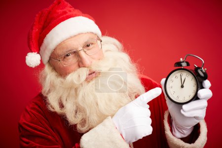 Santa Claus pointing at clock