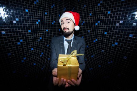 Businessman in Santa cap holding giftbox