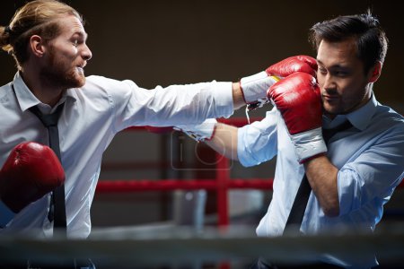 Businessmen in suits and boxing gloves