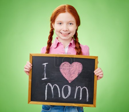 Girl holding blackboard with love declaration to mom