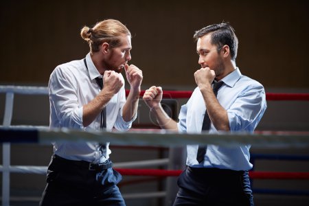 Businessmen fighting on boxing ring