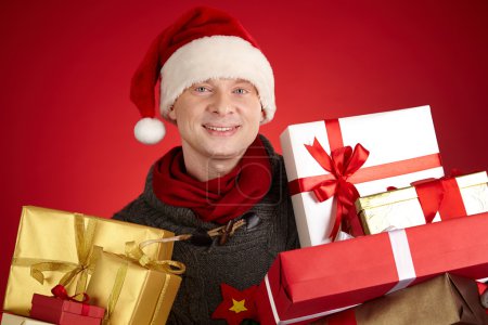 Man in Santa cap holding gifts