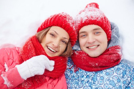 Man and woman lying in snow