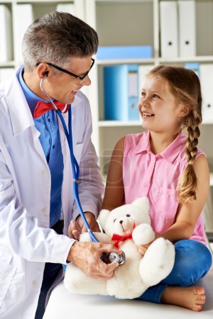 Doctor examining teddy bear