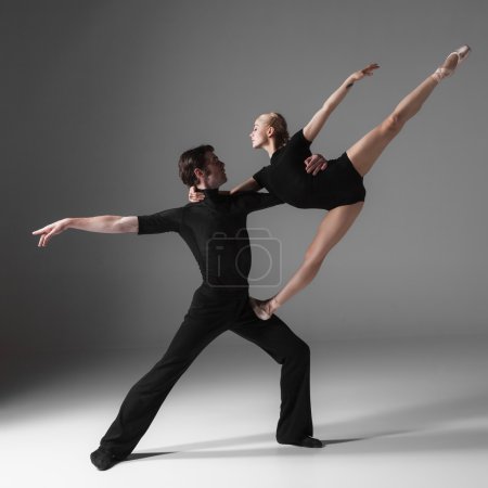 two young modern ballet dancers on gray studio background 
