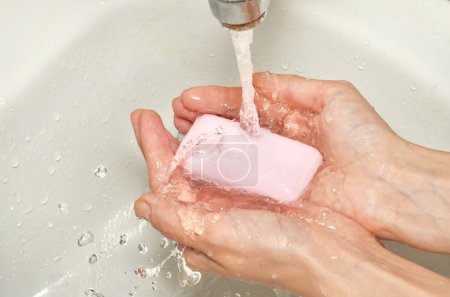 Washing hands with pink soap