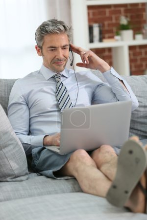 Businessman with headset on couch