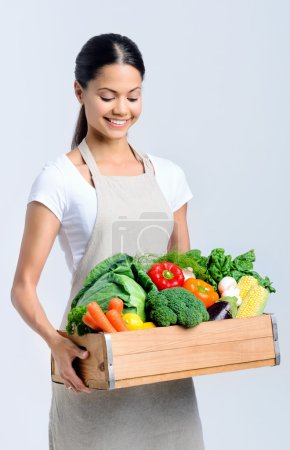 Healthy happy woman with crate of vegetables