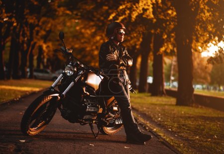 Motorcyclist with a cafe-racer motorcycle outdoors