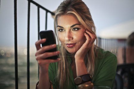 Blonde girl reading an sms on her phone