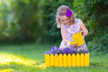 Little girl watering farden flowers