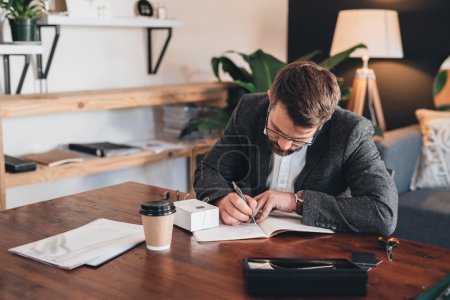 entrepreneur writing in notebook with delivery box