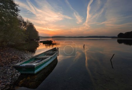Sunset lake with fisherman boat landscape.