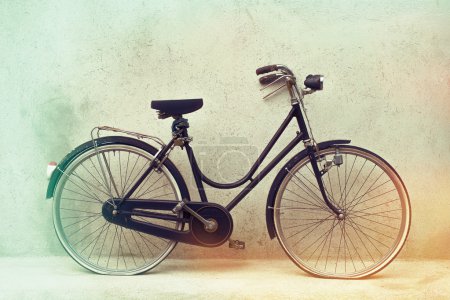 beautiful Old rusty bicycle retro with awesome effect colors on grunge grey background outodoors