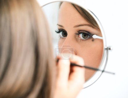 Young woman applying make-up