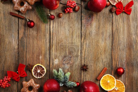 Christmas frame with apples and cookies on wooden table