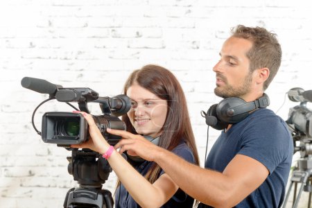 a young man and woman with professional video camera