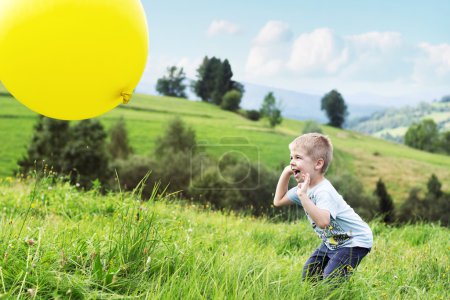 Joyful boy bouncing a balloon