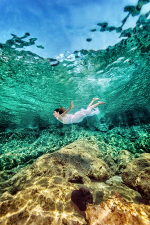 Woman swimming near rock