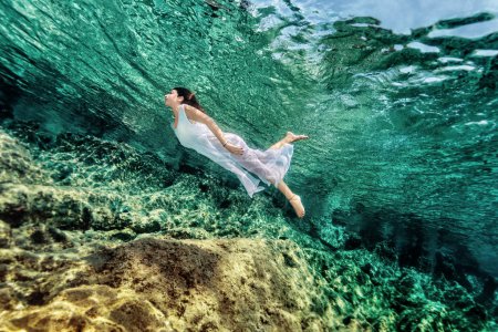Woman swimming near rock