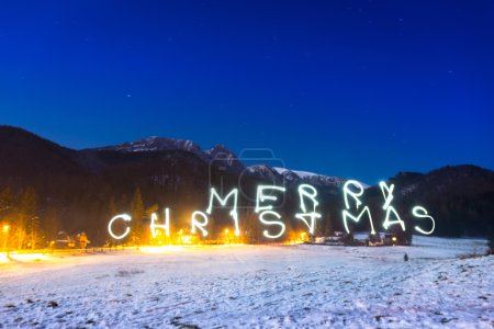 Merry Christmas sign under Tatra mountains at night