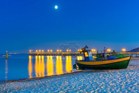 Baltic beach with fishing boat at night