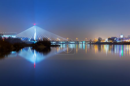 Vistula river scenery with cable-stayed illuminated bridge in Warsaw