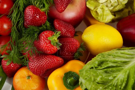Photo of a table top full of fresh vegetables, fruit, and other