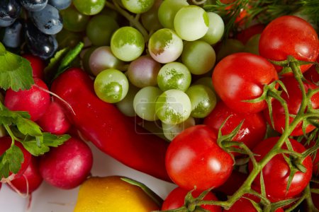 Photo of a table top full of fresh vegetables, fruit, and other