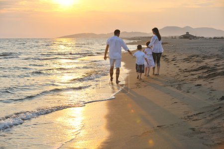 Happy young family have fun on beach at sunset