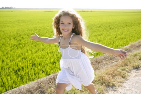 Running open arms little happy girl in meadow track